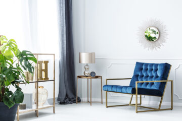 Navy,Blue,Armchair,Next,To,Table,With,Gold,Lamp,In