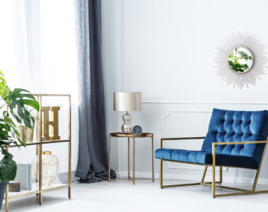 Navy,Blue,Armchair,Next,To,Table,With,Gold,Lamp,In